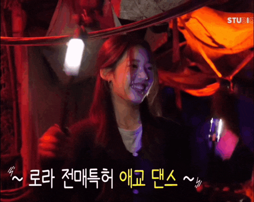 a girl is smiling in front of a sign that says studio on it