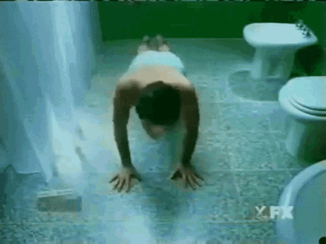 a man doing push ups in a bathroom with a fx logo on the bottom