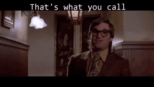 a man in a suit and tie is standing in a hallway with the words `` that 's what you call '' above him .