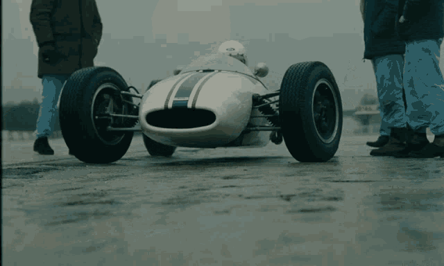 a man in a white helmet is driving a white race car