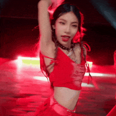 a woman in a red dress is dancing on a stage