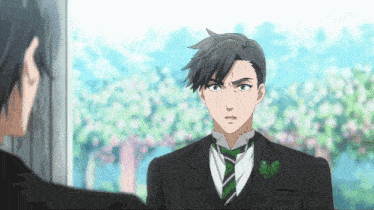 a man in a tuxedo is looking at another man
