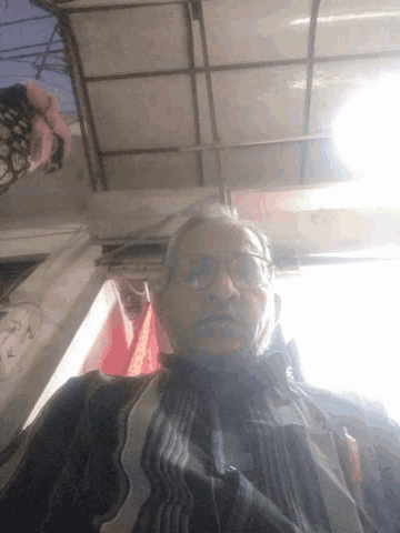 a man wearing glasses is standing in front of a door