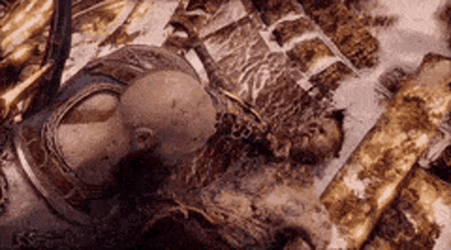 a man in armor is laying on a pile of gold .
