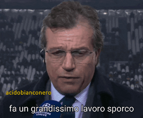 a man talking into a microphone with the words fa un grandissimo lavoro sporco behind him