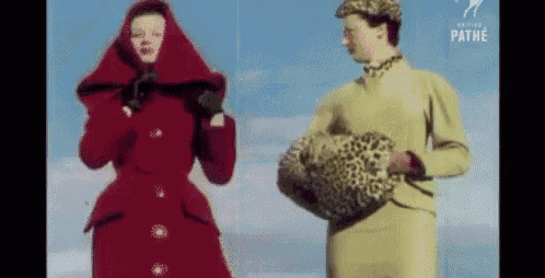 a woman in a red coat is standing next to a woman in a yellow dress .