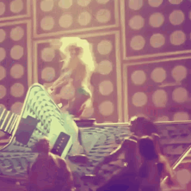 a blurry picture of a woman dancing in front of a wall with dots on it