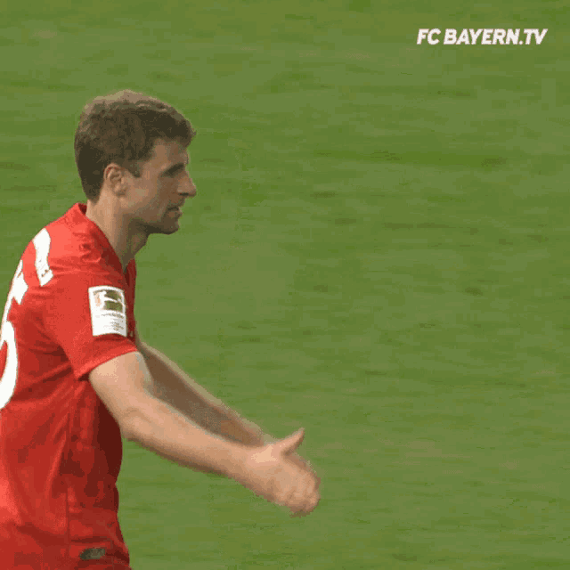 two soccer players shaking hands with fc bayern.tv written on the bottom