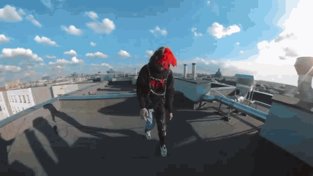 a person standing on a roof with a hoodie that says ' r.i.p. ' on the front