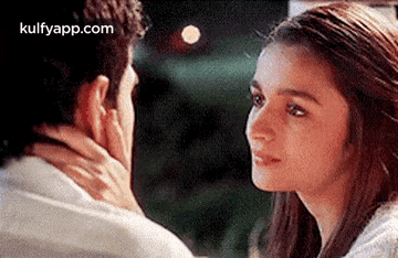 a man and a woman are looking into each other 's eyes and touching each other 's faces .