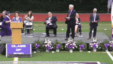 a woman stands at a podium with a sign that says class of 2021