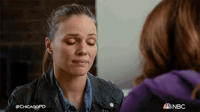 a woman with her eyes closed has #chicagopd on her jacket