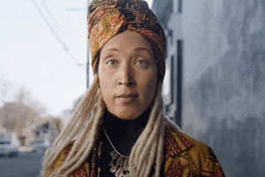 a woman with dreadlocks wearing a turban and a necklace .