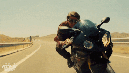 a man riding a motorcycle on a highway with the word tom cruise on the bottom right