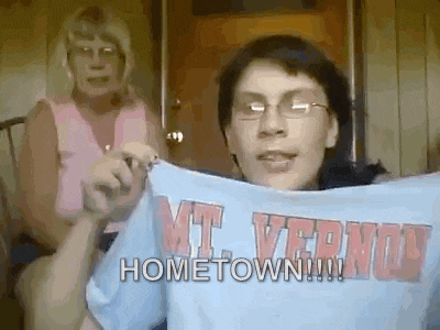 a woman is holding a t-shirt that says hometown