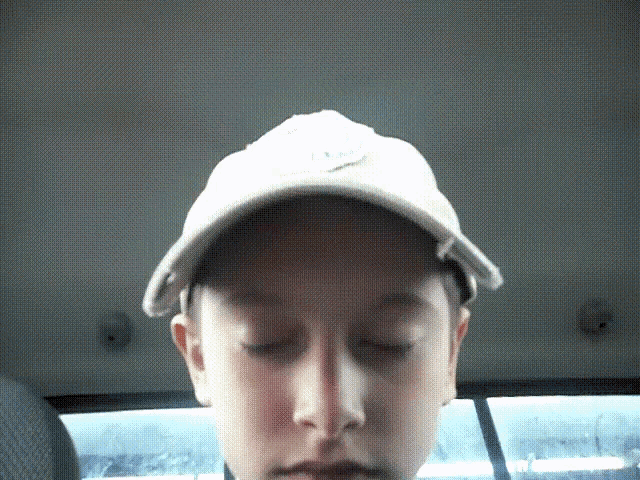a young boy wearing a white hat with the letter t on it