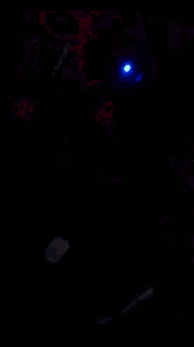 a computer mouse is lit up with blue lights in the dark