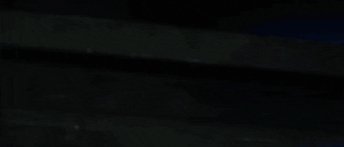 a woman with red hair is laying down in a dark room with a bunch of coffins .