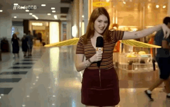 a woman holding a microphone in a shopping mall