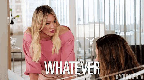a woman in a pink shirt is talking to another woman and says whatever
