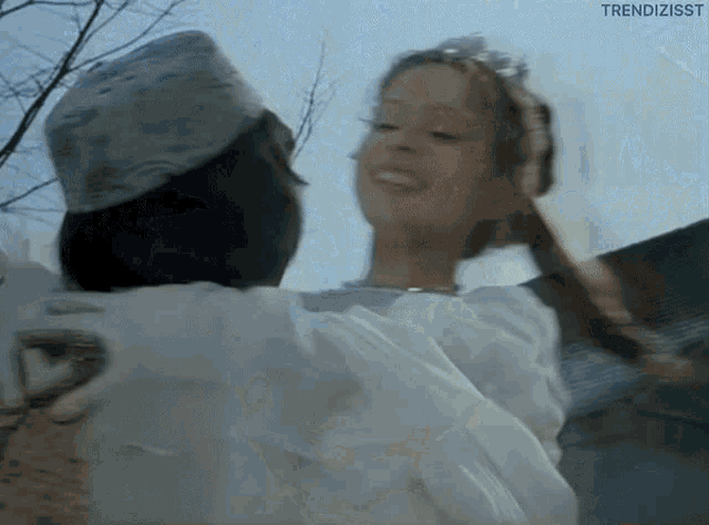 a man is carrying a woman in his arms and the words trendizisst are on the bottom