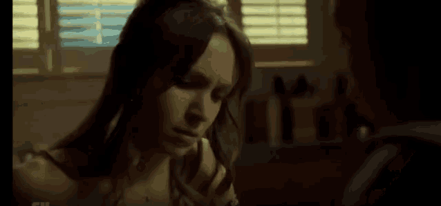 a man and a woman are looking at each other in a dark room .