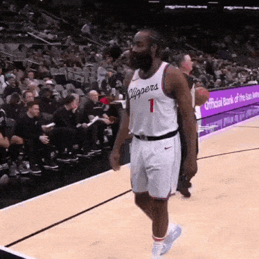 a basketball player with the number 1 on his jersey walks on the court