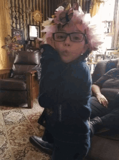 a little girl wearing glasses and a flower crown