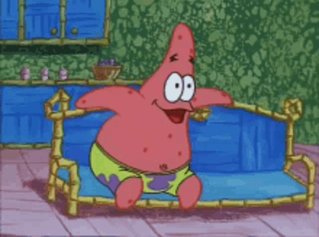 patrick star from spongebob sits on a blue couch with his mouth open