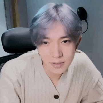 a close up of a person 's face with purple hair .