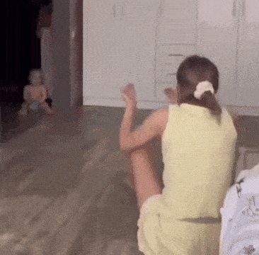 a girl in a yellow dress is sitting on the floor in a living room .