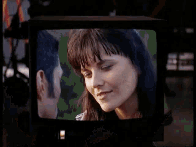 a man and a woman are looking at each other on a television screen .