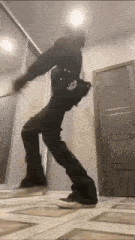 a man is dancing in a hallway in front of a door .