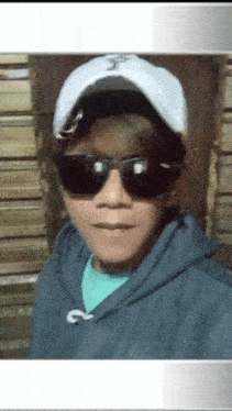 a young man wearing sunglasses and a white hat