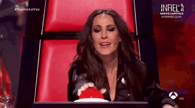 a woman is sitting in a chair and pressing a button .