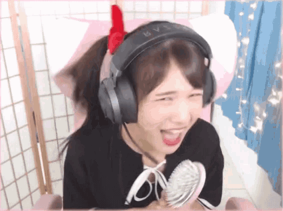 a girl wearing headphones and holding a fan with the letter v on it