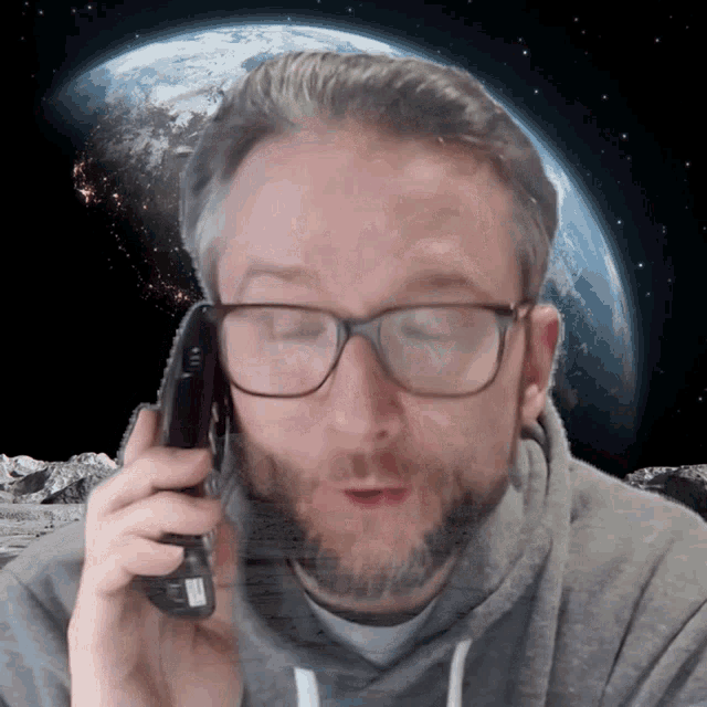 a man wearing glasses is talking on a phone