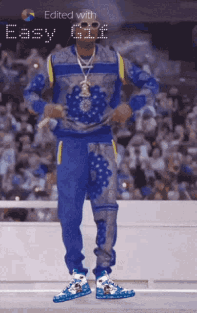 a man in a blue sweater and blue pants is standing in front of a crowd with the words edited with easy gif visible
