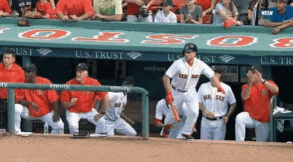 a group of baseball players are standing in a dugout with a banner that says u.s. trust