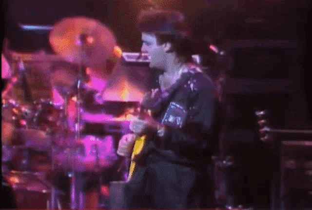 a man playing a guitar with a sticker on his shirt that says ' a.r.p.t. '