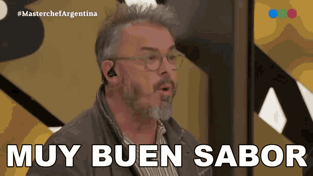 a man with glasses and a beard says " muy buen sabor "