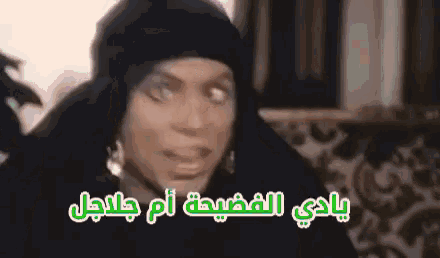 a woman wearing a black hat and earrings is making a funny face in arabic .
