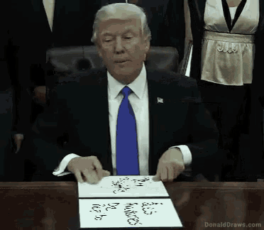 donald trump sits at a desk with a piece of paper that says donalddraws.com