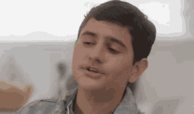 a young boy is making a funny face with his mouth open .