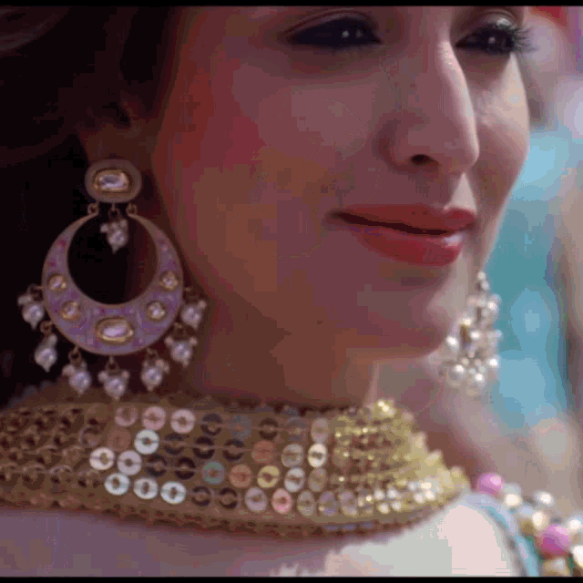 a close up of a woman 's face wearing earrings and a necklace