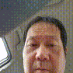 a close up of a man 's face in a car with a blurred background
