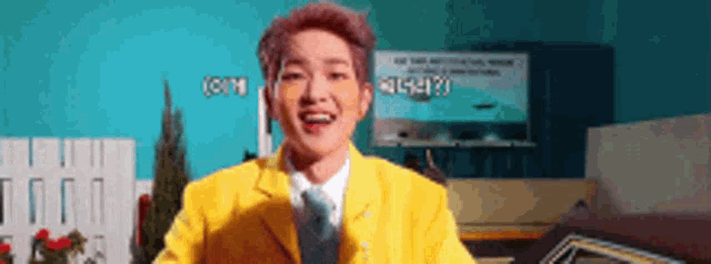 a man in a yellow jacket and tie is smiling while standing in front of a car .