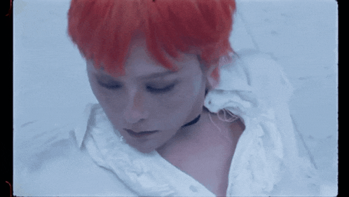a woman with red hair is wearing a white shirt and a choker
