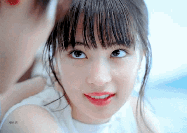 a close up of a woman 's face with korean writing on the bottom left