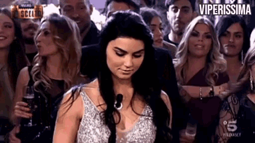 a woman is standing in front of a crowd of people .